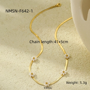Detail of gold snake chain necklace with five white daisy flowers on stone display