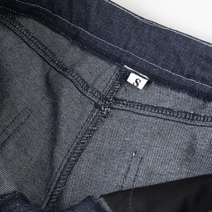 Détail de l'étiquette taille S sur la ceinture intérieure du pantalon en jean bleu foncé