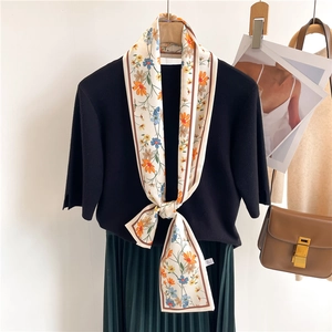 Foulard étroit en soie à imprimé floral porté sur un pull avec un sac marron