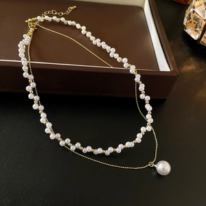 Gros plan d'un collier de perles double épaisseur avec fermoir doré sur écrin