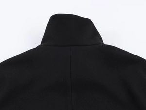 Detailed view of the black stand collar and textured fabric on the short coat