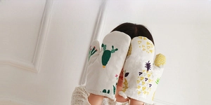Close-up of heat-resistant cotton kitchen glove with green cactus and pineapple prints