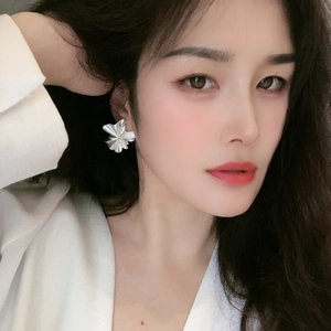 Elegant ruffled silver petal earrings in matte finish worn by a fashion model