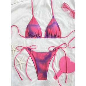 Detailed top view of a pink and purple marble tie-dye bikini with summer beach accessories