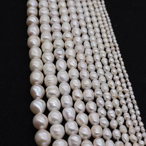 Natural freshwater rice pearls in various sizes and shapes on a dark background