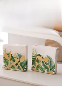 Close-up of golden metal napkin holders with cutlery and wine glass hollow patterns
