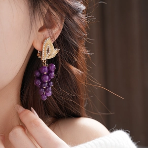 Close-up of vintage French style gold butterfly clip-on earrings with purple beads