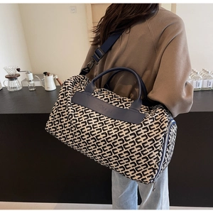 Dettaglio borsa da viaggio blu navy con stampa geometrica e rifiniture in pelle di lusso