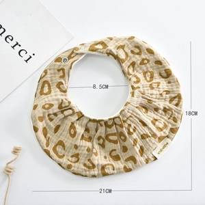 Detailed macro view of brown leopard print baby bib showing soft cotton gauze fabric texture