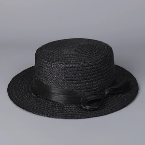 Detailed texture of black woven raffia flat top hat with a wide silk bow ribbon decoration