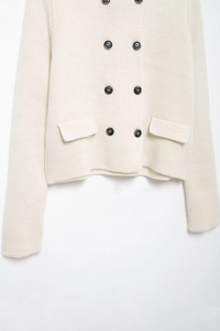 Détail du cardigan en maille blanc crème avec boutons à double boutonnage et poches