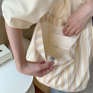 Detail view of canvas tote bag interior showing the magnetic buckle and inner zipper pocket