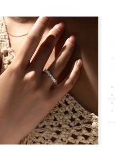 Close-up of sparkling S925 sterling silver eternity ring with round-cut stones on hand
