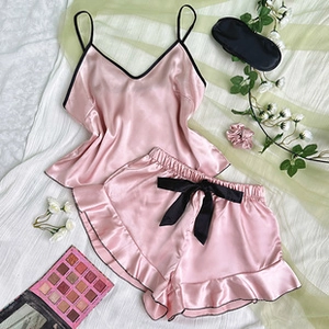 Detailed view of pink satin camisole set with black bow and ruffled hems for women