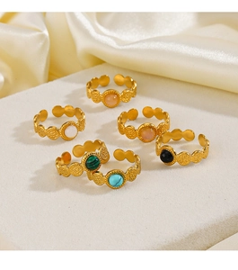Detail of adjustable gold rings with turquoise and colorful stones on silk fabric