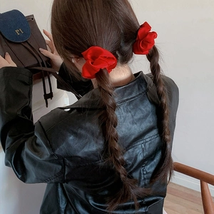 Elegant red satin scrunchies shown on dual ponytail hairstyle from a back view perspective