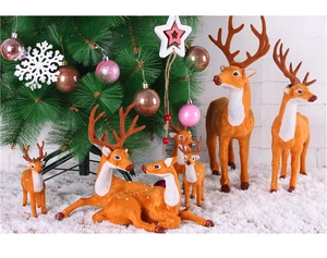 Detailed view of orange-brown flocked reindeer figurines set under a festive Christmas tree