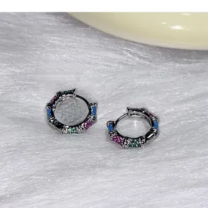 Détail de créoles bambou en argent avec des pierres de zircone rose vert et bleu