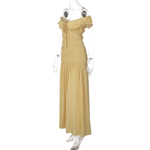 Détail de la robe jaune à col en V avec tissu plissé et finitions texturées sur les manches