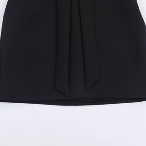 Detailaufnahme der hochwertigen Stofftextur und Banddetails an einem schwarzen Kleid