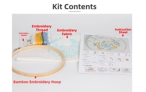 DIY embroidery kit detail showing bamboo hoop, colorful threads, and printed fabric