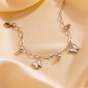Detail of silver stainless steel paperclip chain bracelet with white shell butterfly charms