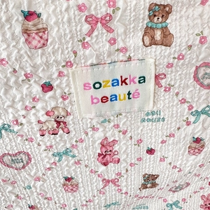 Detailed macro shot of quilted seersucker fabric featuring cute bear and floral prints