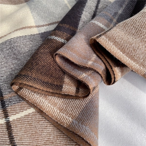 Close-up of thick plaid wool texture showing soft brown and beige woven fibers