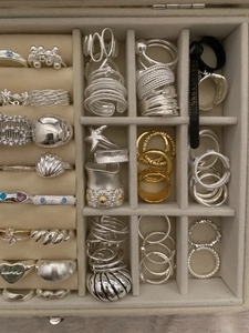 Detailed top view of a jewelry box containing vintage silver and gold minimalist rings