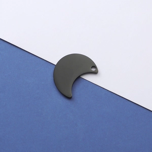 Detail view of a black moon-shaped stainless steel pendant with a single hanging hole