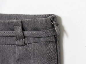 Dettaglio vita gonna grigio scuro con cerniera invisibile e trama in tessuto twill