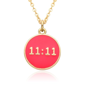 Detailed macro view of 11:11 red enamel round pendant with gold plating on white surface