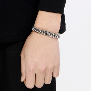 Macro detail of silver stainless steel Cuban link chain necklace on a model's neck