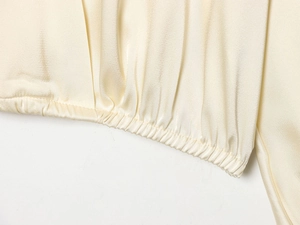 Vue détaillée du chemisier en satin avec poignets élastiques à volants et tissu soyeux