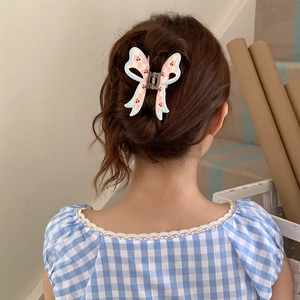 Detail of checkered butterfly hair claw with cherry print on model's hair
