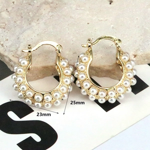 Detail view of pearl hoop earrings in gold with precise 23mm and 25mm dimensions