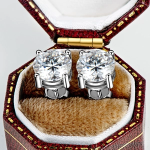 Close-up of D-color moissanite stud earrings in a red vintage leather jewelry box