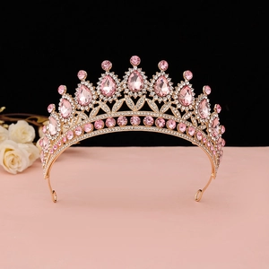 Dettaglio corona di lusso dorata con strass rosa e cristalli a forma di goccia