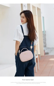 Close-up of pink crossbody bag with vintage floral print and embroidered LOVE strap