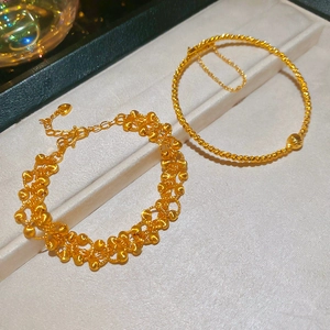 Close-up of 24K gold plated beaded bracelets with intricate woven and pendant designs