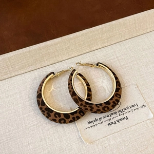 Detailed macro view of leopard print flocked hoops with golden metal inner rings