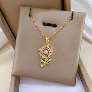 Close-up of golden sunflower necklace featuring sparkling red, green and clear crystals