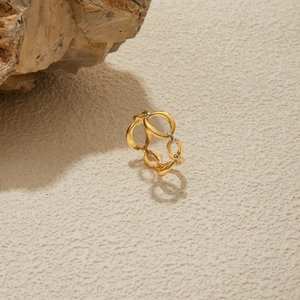Détail d'une bague ajourée en acier inoxydable plaqué or 18K sur décor minéral