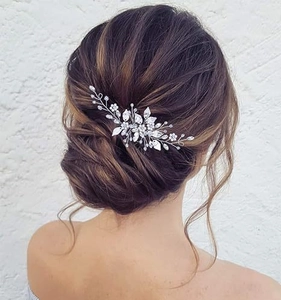 Detail view of silver leaf bridal hair comb with pearls styled on a hair bun