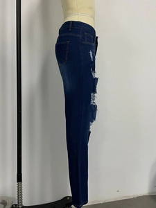 Détail d'un jean skinny bleu foncé avec des déchirures latérales sur un mannequin de couture