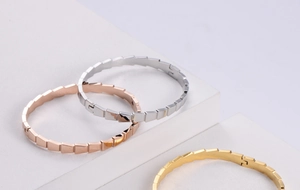 Macro detail of geometric faceted bracelets in gold, silver, and rose gold finishes