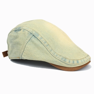 Close-up of vintage washed denim flat cap with brown suede brim and stitched texture