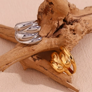 Polished 18K gold and silver dome rings with wavy twisted design on a branch
