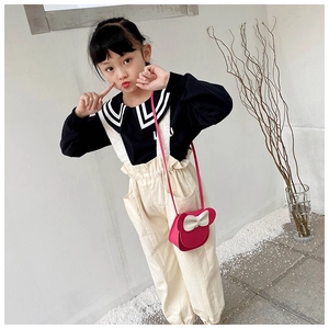 Fashionable young girl wearing a pink mouse-shaped crossbody bag with a white bow detail