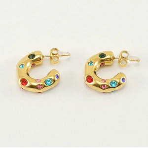Detailed view of C-shaped gold earrings with colorful rhinestones on a white background
